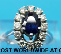 An 18ct white gold ring set with an oval sapphire surrounded by diamonds (size N)