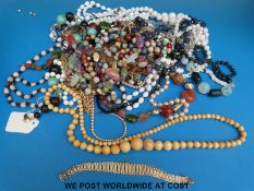 A collection of beaded necklaces to include glass and an ivory example together with a silver