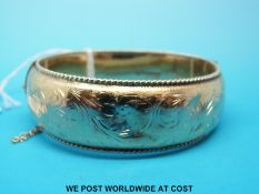 A hallmarked 9ct gold bangle with chased decoration, Chester 1960 (31.