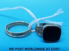 A yellow metal ring set with blood stone and another yellow metal ring made up of three bands