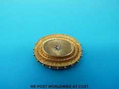 A hallmarked 15ct gold brooch set with a diamond