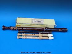Three descant recorders by Schott, two in maple and a bakelite,