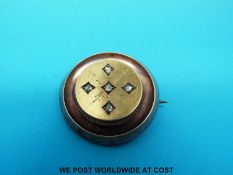 A Victorian brooch of Etruscan design set with five rose cut diamonds with compartment to the back