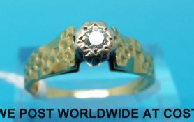 An 18ct gold ring with textured shoulders,