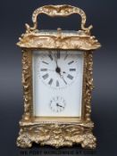 A French half hour repeater and alarm carriage clock in ornately decorated brass case,