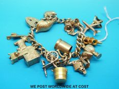 A 9ct gold charm bracelet with 17 9ct gold and yellow metal charms to include Concord, Scottie dog,