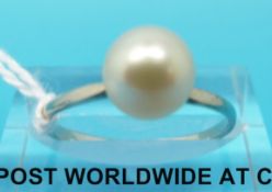 A white metal ring set with a large pearl (size N)