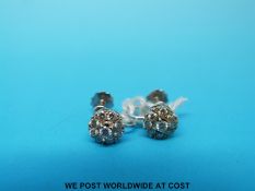 A pair of 9ct gold earrings set with diamonds in a cluster