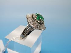A white metal ballerina ring set with a square emerald measuring approx 1.