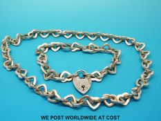 A white metal necklace and bracelet with heart shaped links stamped 925,