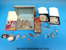 A quantity of costume jewellery to include an amber brooch, marcasite brooches, enamel buttons,