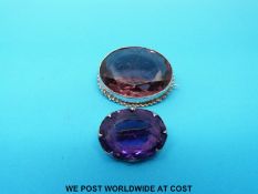 A silver brooch set with an amethyst by Charles Horner and another similar brooch