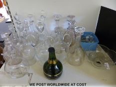 A large collection of glass decanters and extra stoppers