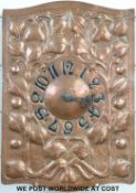 An Arts & Crafts copper wall clock with hammered foliate design with quartz movement