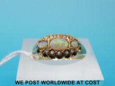 An 18ct gold ring set with three opals and old cut diamonds,