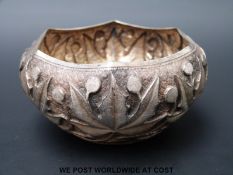 A white metal embossed dish with foliate decoration,