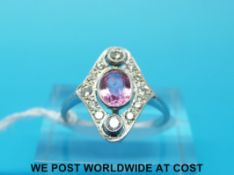 An 18ct white gold ring set with an oval pink sapphire surrounded by diamonds (size M)