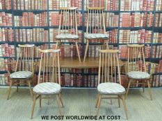 A light elm Ercol table and six chairs (4+2) (H70 x L150 x D80cm)