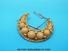 A Victorian gold crescent shaped brooch decorated with filigree and spheres