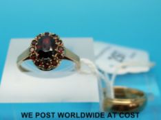 A 9ct gold ring set with garnets in a cluster and a 9ct gold wedding band