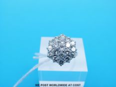 A platinum ring set with 19 round brilliant cut diamonds in a cluster,