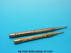 Two yellow metal propelling pencils