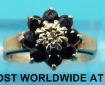 A 9ct gold ring set with a central diamond surrounded by sapphires (size L)