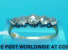An 18ct gold yellow metal ring marked 18ct set with five graduated diamonds in a platinum setting,