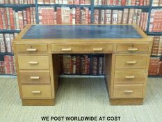 A light oak twin pedestal leather inset desk (H76 x L137 x D70cm)