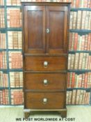A 19thC mahogany cupboard over three drawers with lion mask loop handles raised on bracket feet