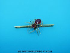 A yellow metal brooch set with garnets in the form of a spider