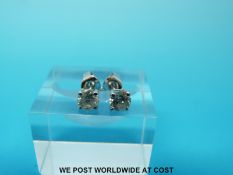 A pair of 18ct white gold earrings each set with a round brilliant cut diamond measuring