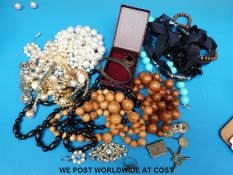 A quantity of costume jewellery to include bead necklaces, stamp case marked sterling silver,