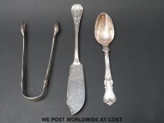 A Victorian hallmarked silver butter knife, Victorian teaspoon and Georgian sugar tongs,