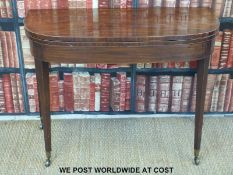 A 19thC mahogany fold over card table raised on square tapering legs and brass castors (H74 x L102