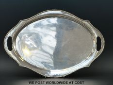 A white metal twin handled tray with beaded edge marked to underside,