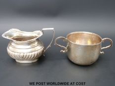 A hallmarked silver porringer, London 1913 and a hallmarked silver milk jug,