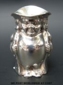 A George V hallmarked silver novelty Toby jug formed as a gentleman in long jacket holding a pipe,