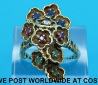 An 18ct gold ring made up of ten petal shapes set with three square sapphires, three square rubies,