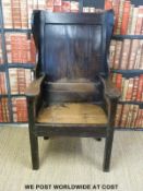 An 18th/19thC peg jointed oak wing backed chair with simple plank back,