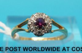 An 18ct gold ring set with a central ruby surrounded by diamonds in a platinum setting (size M)