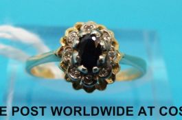 An 18ct gold ring set with an oval sapphire surrounded by diamonds (size M)