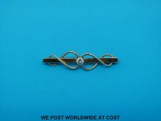 A 9ct gold brooch set with a round brilliant cut diamond (3.