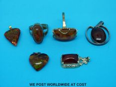Two yellow metal rings marked 333 set with amber and three amber pendants