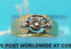 An 18ct gold ring set with three diamonds with bark texture to the band,