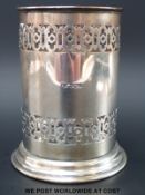 A George V hallmarked silver bottle holder with period decoration,