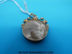 A yellow metal two sided locket marked 15ct gold set with seed pearls