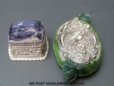 Two hallmarked silver pin cushions, one of flattened form with figural decoration, B'ham 1906,