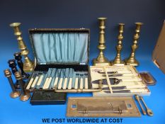 Three sets of brass candlesticks including ejector types, a pair of ebony examples,