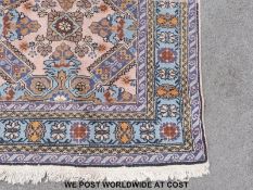 An Persian woollen rug on a pink ground (247 x 166cm)